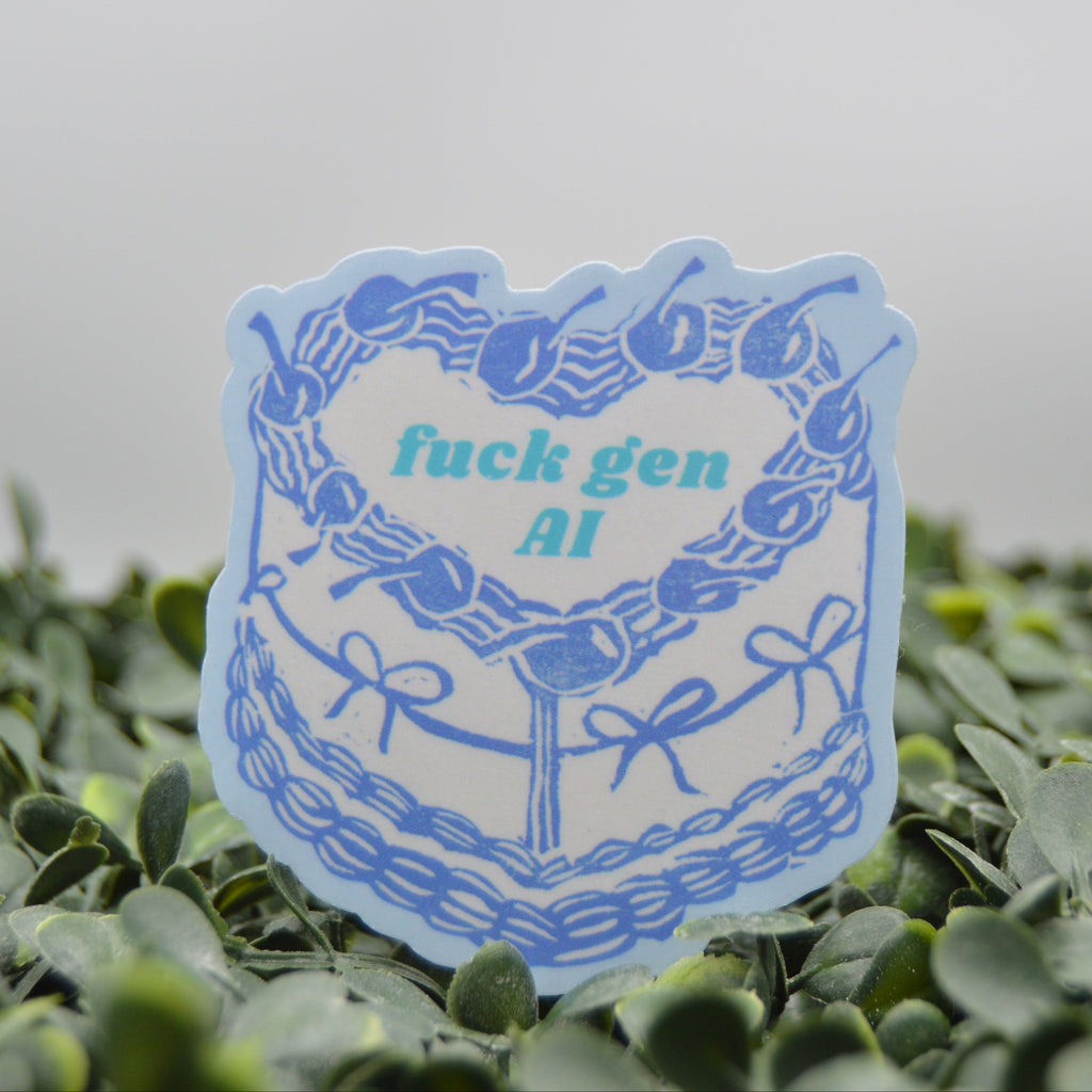 A die-cut sticker with a light blue border and a white center featuring the text 'fuck gen AI' in teal, surrounded by a blue illustration of cherries and bows, displayed on green foliage against a gray background.